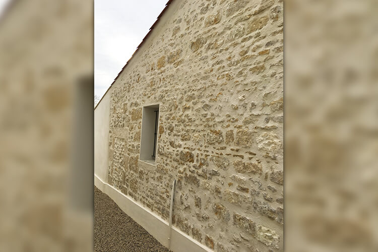 Façade extérieure d'une habitation en pierres apparentes rénovée par Roland Gorge, Maçon à Angles, Grues et La Tranche Sur Mer - couvreur Saint Benoist Sur Mer, couvreur Saint Denis du Payré